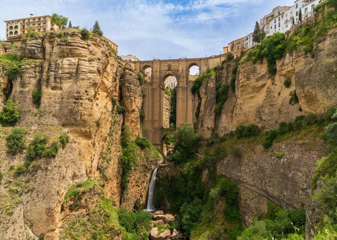 Puente Nuevo w Rondzie widziany z dna wąwozu El Tajo, z wodospadem rzeki Guadalevín pod mostem