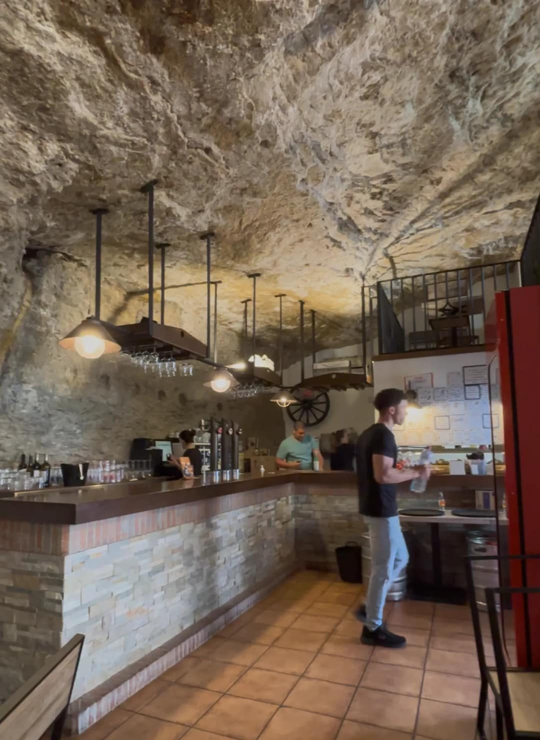 Wnętrze baru w Setenil de las Bodegas z kamiennym sufitem z litej skały nad ladą i lampami